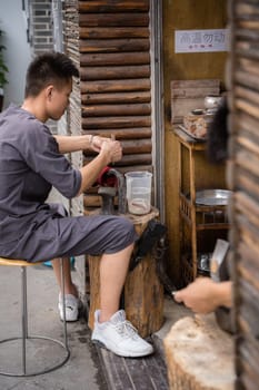 Xian, China -  July 2019 : Man using hammer to make crafts on the street market in the Muslim Quarter, Xian town, Shaanxi Province