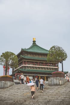 Xian, China -  July 2019 : People climbing up the stairs leading to the landmark Drum Tower in the city Xian, Shaaxi Province, Central China