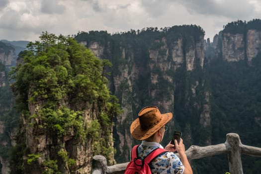 Zhangjiajie, China - August 2019 : Tourists admiring the view and taking pictures on the smartphone on the Bridge Heaven Pillar viewpoint, Avatar mountains nature park