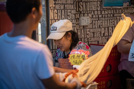Xian, China -  July 2019 : Older man preparing dough for noodles and pasta in a traditional way on the street in the Muslim Quarter