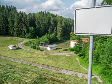 View from the dam on the power plant at the Lake Gruenten with empty sign in the foreground in summer 2019.