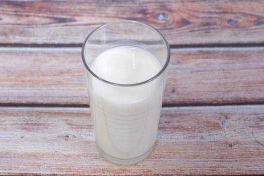 glass of milk on wooden background from above