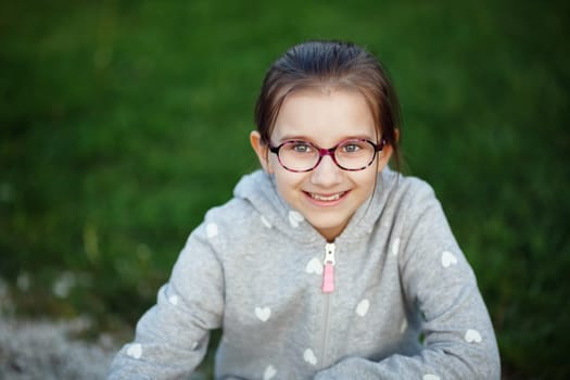 Smiling child girl with glasses outdoors. Selective focus.