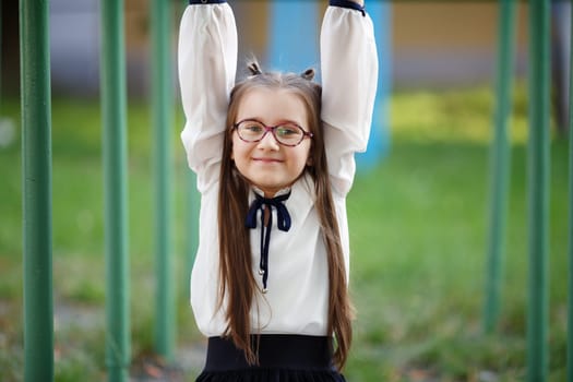 Happy child girl on the playground. Schoolgirl having fun on the playground. Selective focus.