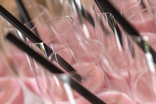 Sherbets into the cups with black straws ready to serve. Closeup.