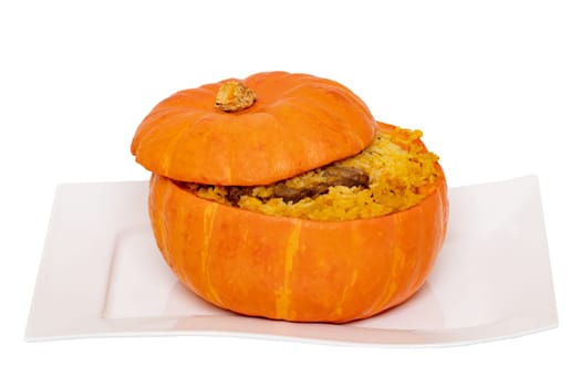 Roasted pumpkin. Close-up of baked whole pumpkin stuffed with roasted rice pot made from rice, onions, carrots, garlic, pumpkin and beef on a white plate isolated on a white background.