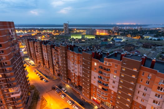 Volgograd, Russia - August 24, 2019: Cityscape aerial view with a view of the new residential district under construction and the Volga River after sunset