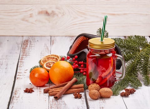 Winter holidays still life with fir tree branch, ski glasses, fruit tea, spices and oranges on a light wooden background with copy space. New Year and Christmas. Winter vacation.