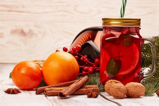 Winter holidays still life with fir tree branch, ski glasses, fruit tea, spices and oranges on a light wooden background with copy space. New Year and Christmas. Winter vacation.