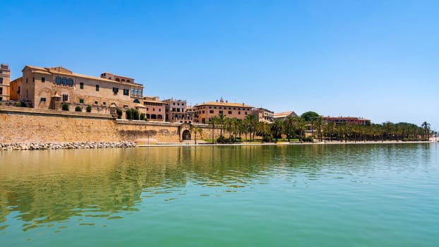 View from sea on beautiful generic old town, Catalonian style cityscape with green palms trees, Palma de Mallorca, Spanish architecture