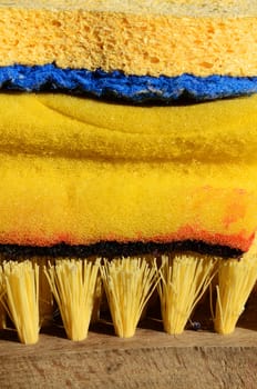 Cleaning supplies in yellow with sponge and brush for house work