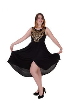 A beautiful young woman standing in a long black dress lifting.up her dress, isolated for white background.