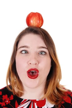 A close up image of a young woman with an apple on her head, her.mouths open and eyes crossed, isolated for white background.
