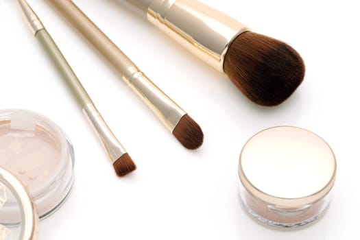 closeup of make up powder and brush on white background