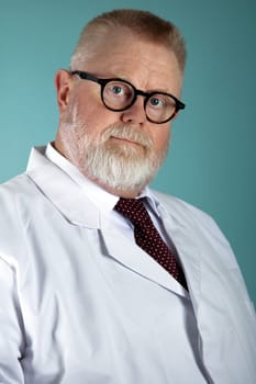 Matured, confident caucasian male medical doctor with stetescope and in white coat, on blue background