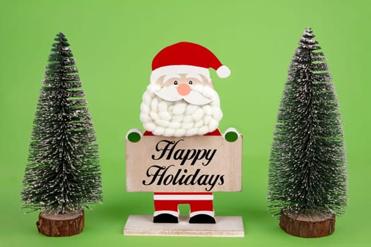 Decorative wooden Santa Clause holding a board with Happy Holidays