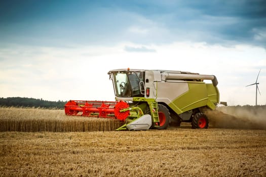 Harvester doing is job on a wheatfield in summer