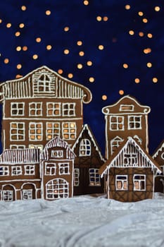 home made gingerbread town and bokeh sky out of blue velvet and christmas lights as advent decoration for the family
