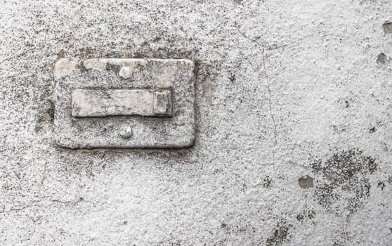 Broken doorbell, covered in paint, on a grungy wall with cracks and molds. Ideal for creative backgrounds.