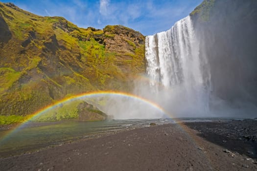 Full Rainbow in the Mist of Colorful Skogafoss Waterfall in Iceland