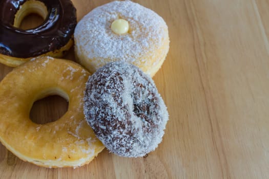 Donuts on wooden background, closeup Delicious a lot of donuts