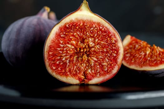 Tropical fig fruit, fresh in half section on the background of whole fruits and quarters
