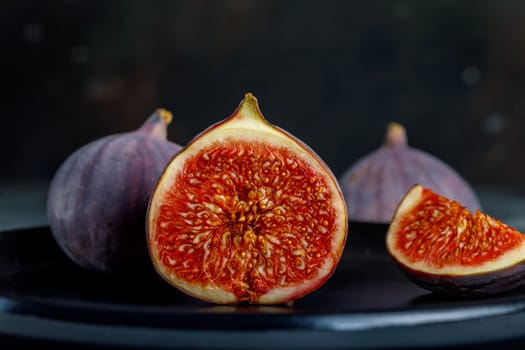 Tropical fig fruit, fresh in half section on the background of whole fruits and quarters