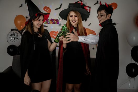 Group of young adult and teenager people celebrating a Halloween party carnival Festival in Halloween costumes drinking alcohol beer