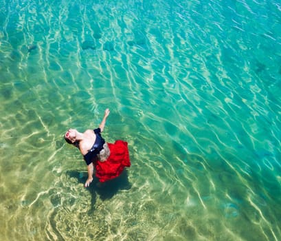 Aerial view of a beautiful woman dancing  in the sea