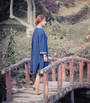 Beautiful woman on a bridge in the flower park, Dalat, Vietnam