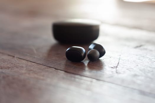 Wireless headphones on wooden background, stock photo