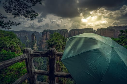Tourists holding green umbrella admiring the view and  on the scenic viewpoint, Avatar mountains nature park, Zhangjiajie, China