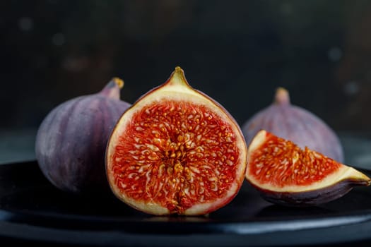 Tropical fig fruit, fresh in half section on the background of whole fruits and quarters