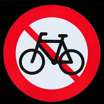 Prohibition sign for bicycles, white-red on a black background, close up