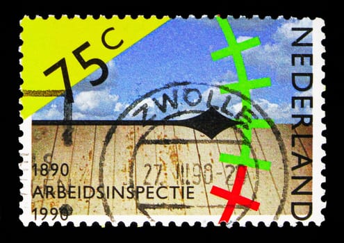 MOSCOW, RUSSIA - MAY 13, 2018: A stamp printed in Netherlands shows Symbolic depiction of measuring labour conditions, Labour Inspection serie, circa 1990