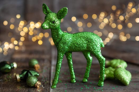 Glittery green Christmas ornaments in front bokeh lights