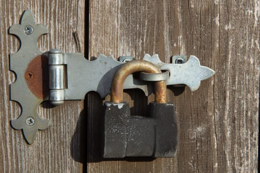 The old big padlock on wooden door