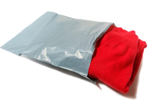 red jumper packed in gray mailing bag