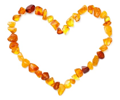 Heart shape made of amber isolated on white background. Polished ambers. Top view, flat lay