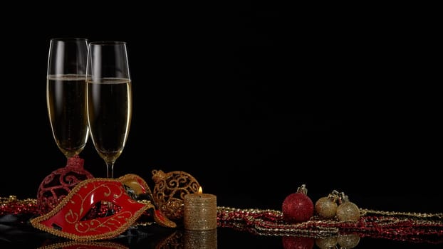 Two wineglasses with champagne and Christmas decorations on a black background. Copy space. New Year and Christmas