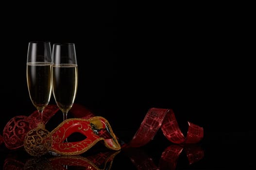 Two wineglasses with champagne and Christmas decorations on a black background. Copy space. New Year and Christmas