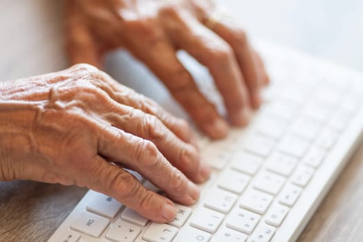 Elderly woman typing on a PC keyboard