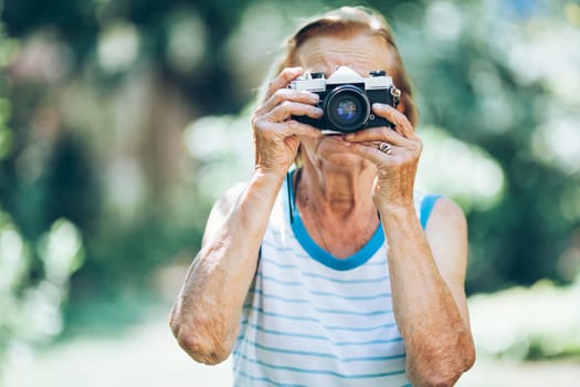 Elderly woman with a vintage film photo camera
