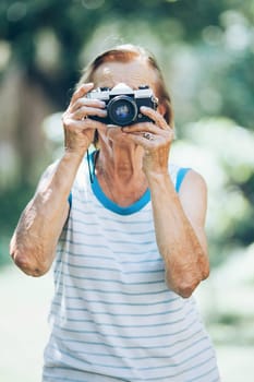 Elderly woman with a vintage film photo camera