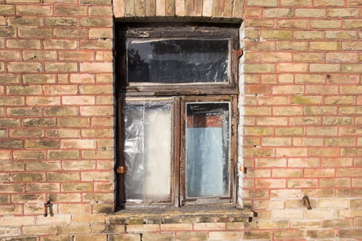 old broken closed window on the brick wall