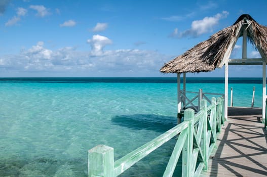 Wooden pier in the Caribbean with turquoise crystal clear water as a background.