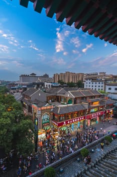Xian, China -  July 2019 : Crowds walking among shops in the bustling streets of the Muslim Quarter in the evening as seen from the viewpoint in rum Tower, Xian city, Shaaxi Province