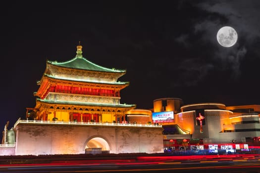 Xian, China -  July 2019 : Blurred lights of a traffic around the Xian Bell Drum Tower, beautifully lit and illuminated at night, Shaaxi Province
