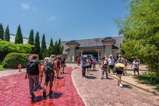 Xian, China -  July 2019 : Tourists walking on a path road leading to a museum site building containing Terracota Army sculptures, Xian, Shaanxi Province