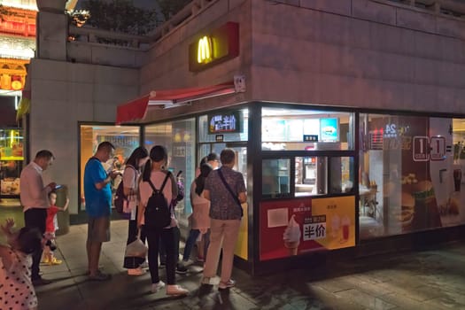 Xian, China -  July 2019 : Chinese people queuing to purchase food at fastfood restaurtant macdonald at night